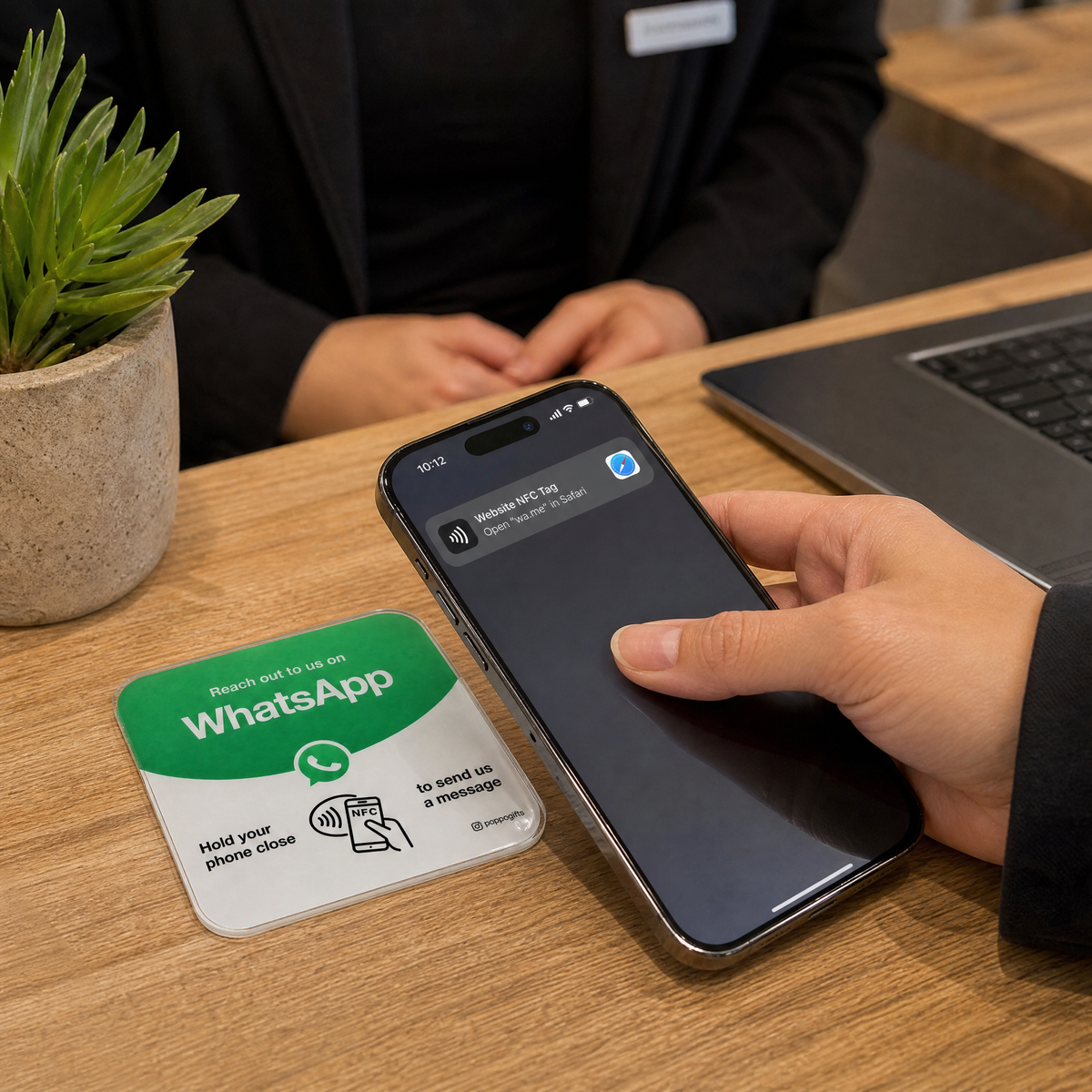 Phone reading a WhatsApp NFC card on a desk